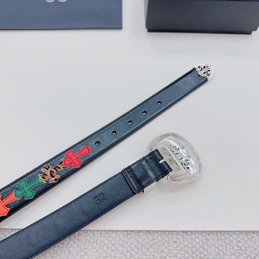 Close view of dark blue belt with multicolor cross detail and clear-prong buckle plate.