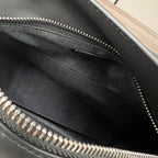 Black fabric-lined interior of a bag with zipper teeth and trim.