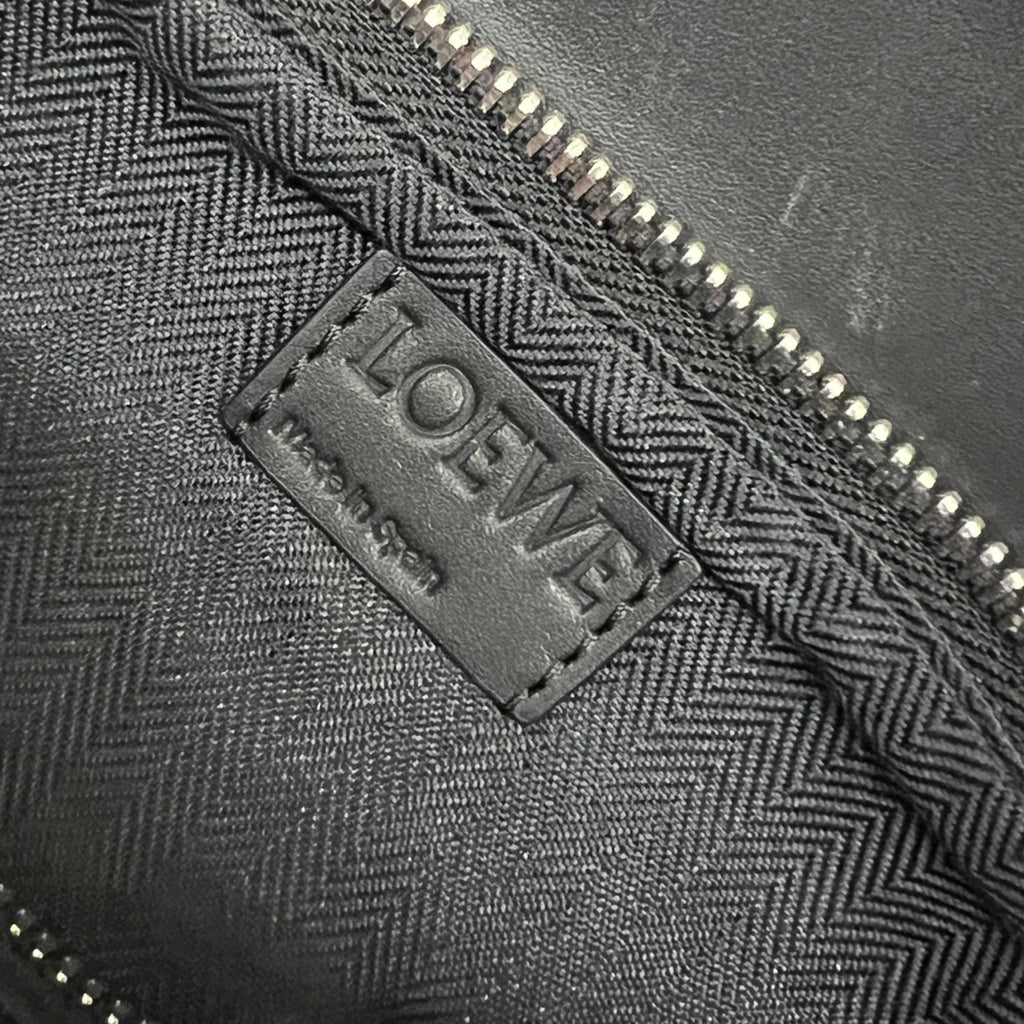 Black patterned lining with LOEWE brand label near zipper edge.