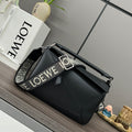 Black leather top-handle bag with silver hardware and front seams.
