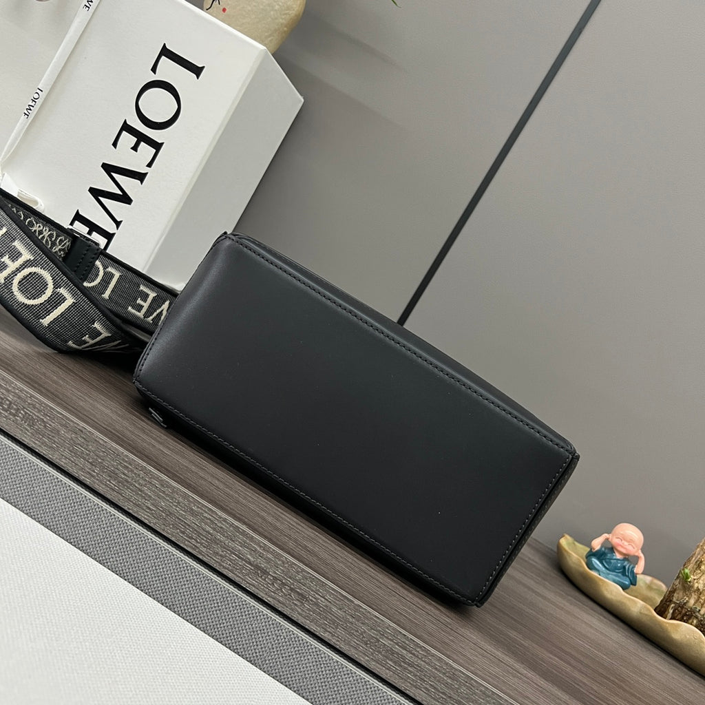 Black leather rectangular clutch bag with smooth front and stitched edges.