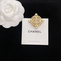 Gold-tone rhinestone Chanel brooch, circular medallion and cross arms