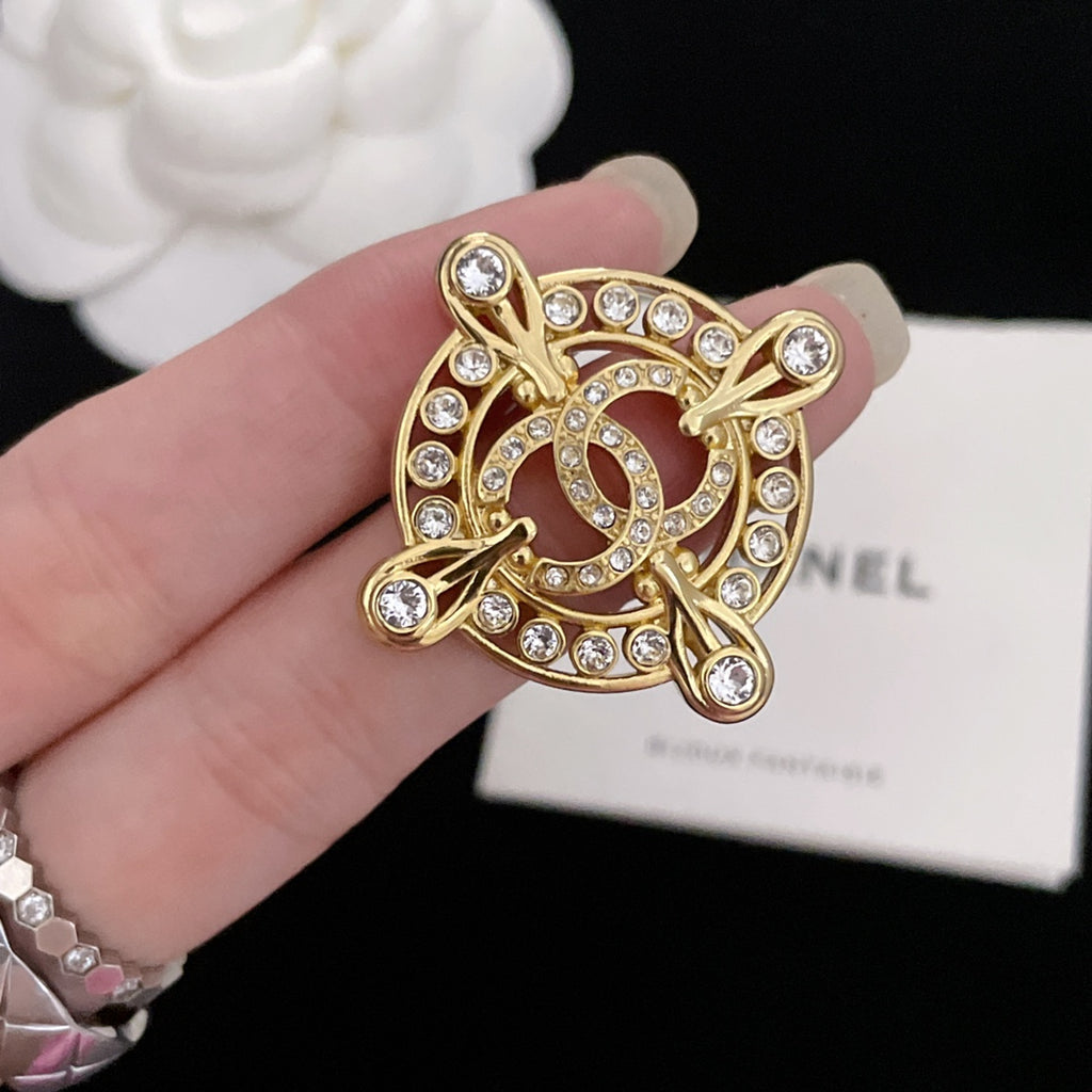 Gold-tone rhinestone Chanel brooch, ornate halo frame held in hand