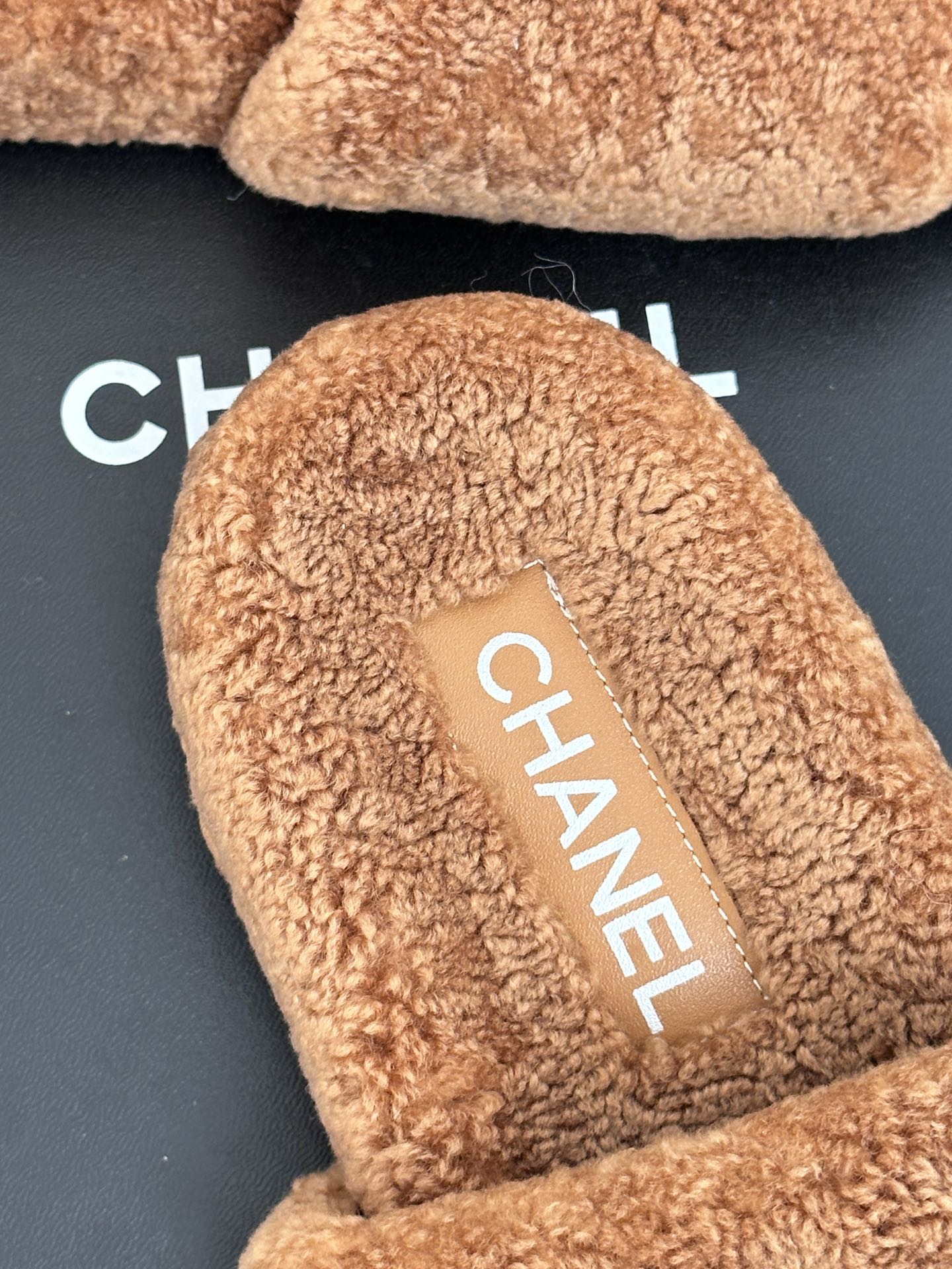 Close-up of tan teddy slide footbed with CHANEL logo