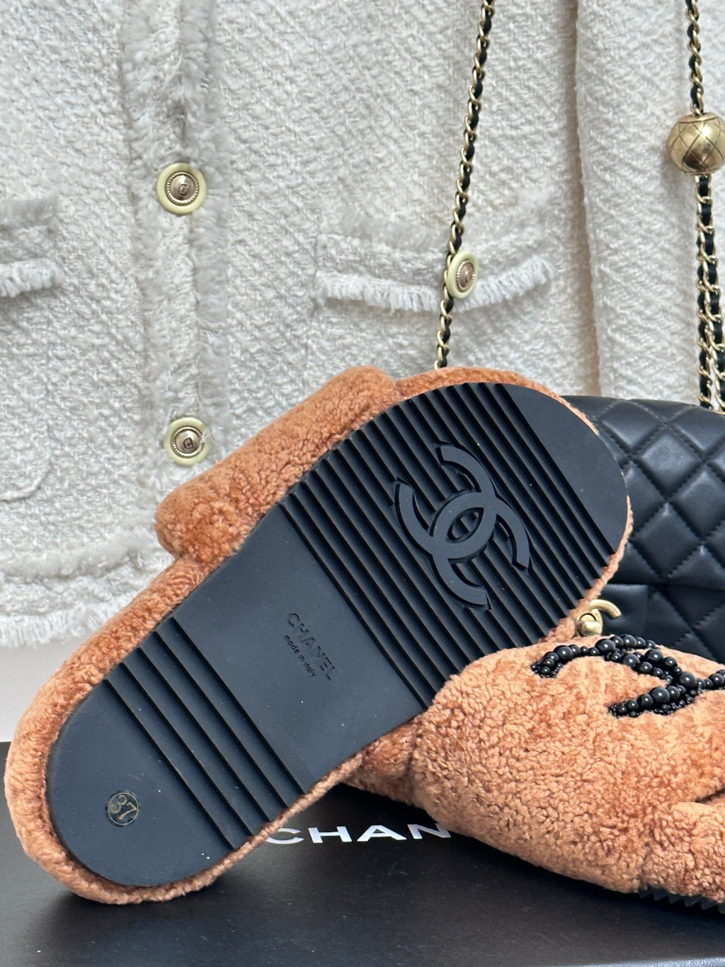 Tan teddy slide sandals showing textured outsole and CHANEL branding