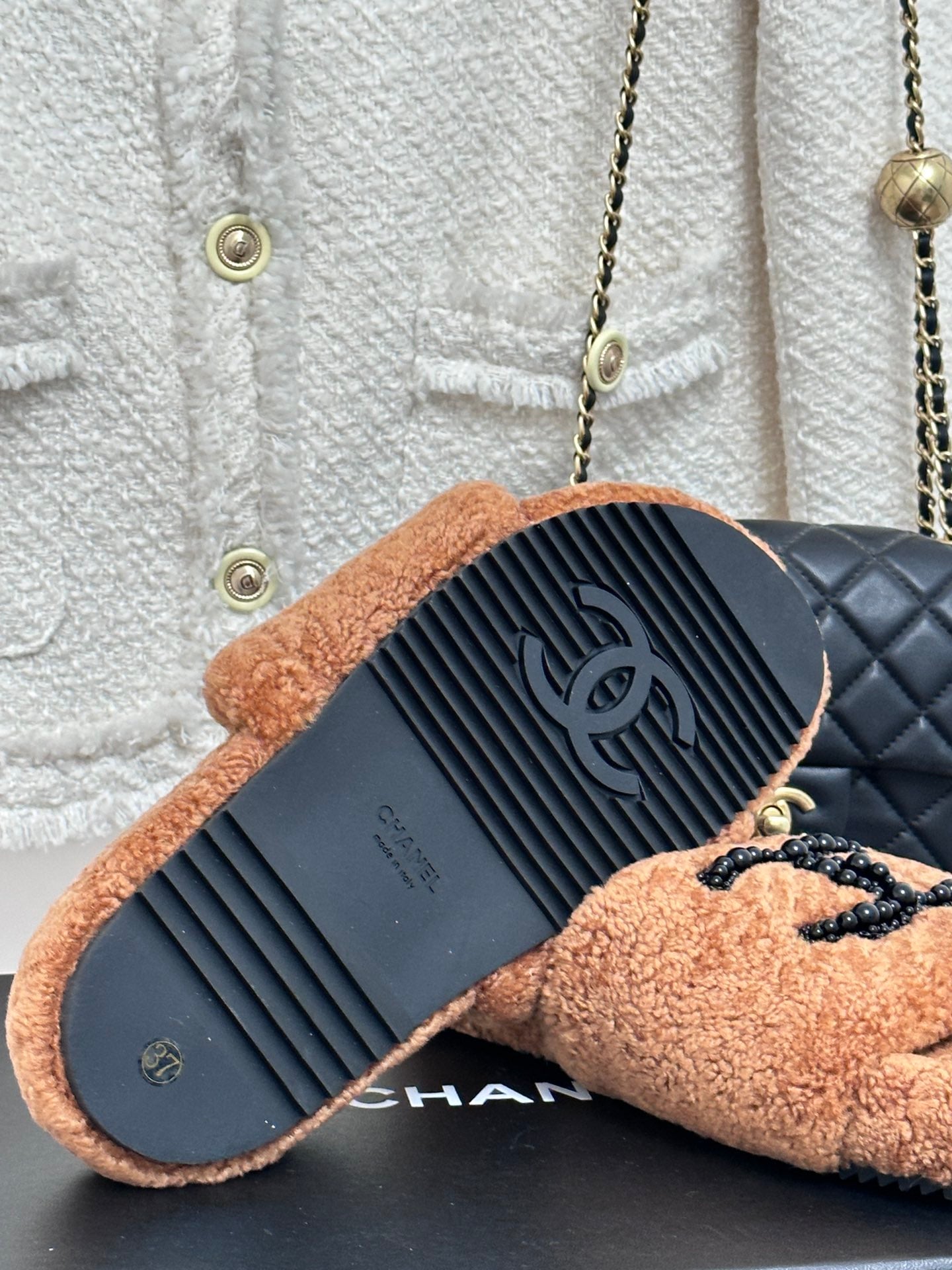 Tan teddy slide sandals showing textured outsole and CHANEL branding