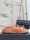 Tan teddy slide sandals with black beaded CC logo on upper
