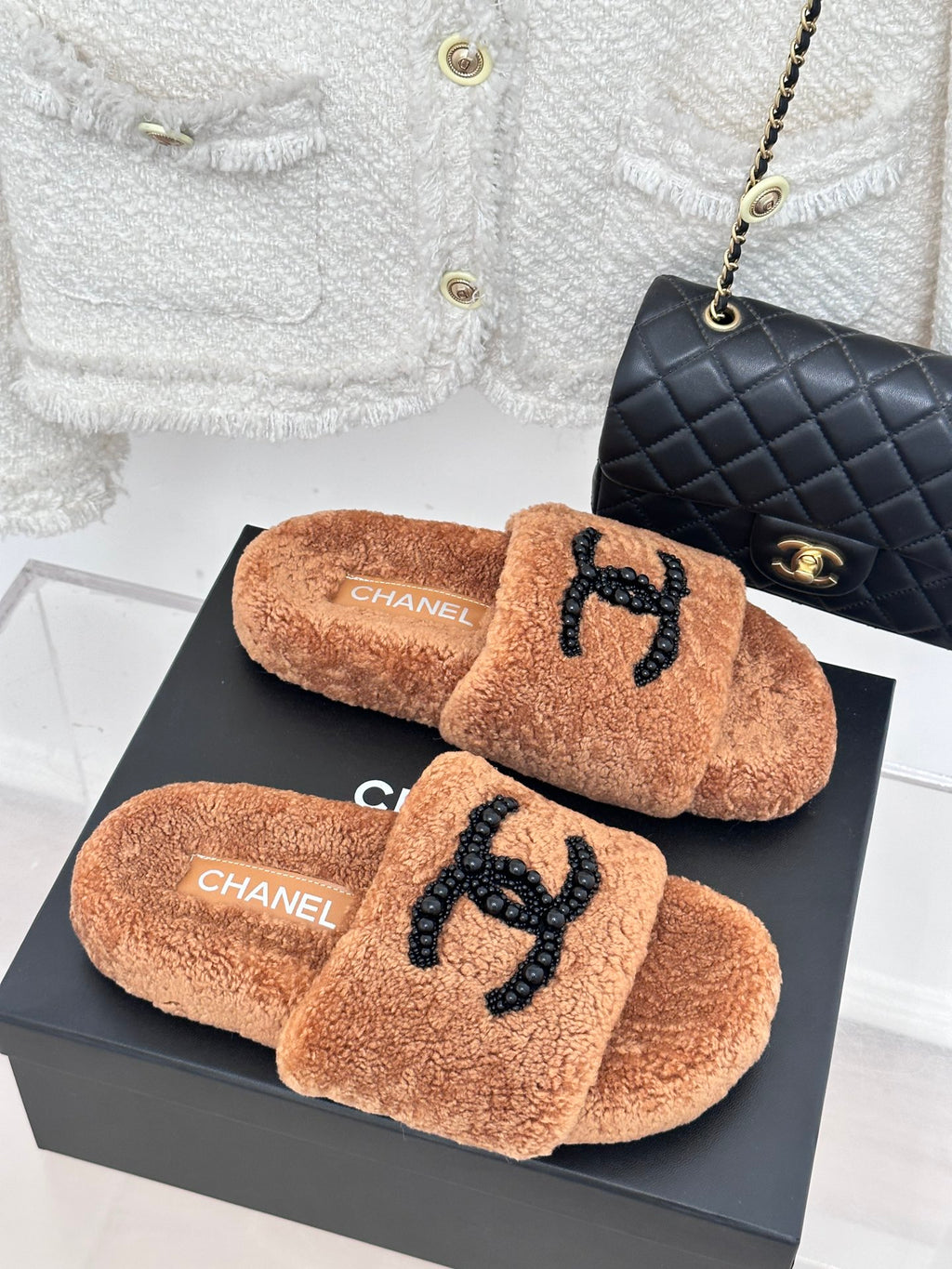 Brown teddy slide sandals with black beaded CC logo and CHANEL branding