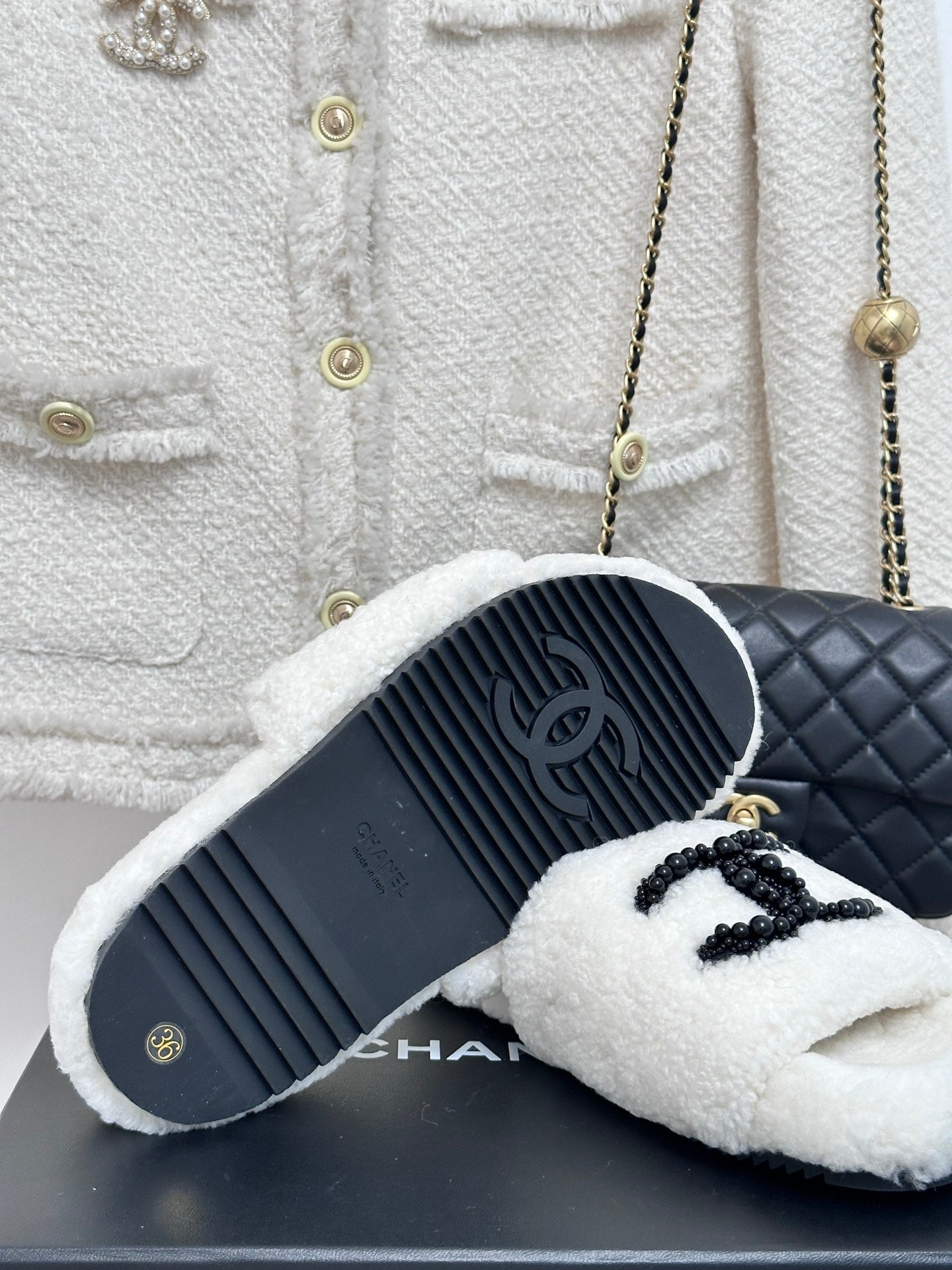 Chanel white fuzzy slides with black CC emblem, outsole and top view