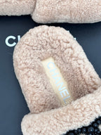Beige sherpa slide close-up with light blue logo label inside, womens luxury shoes
