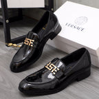 Versace black patent leather loafer pair with gold logo buckle on the front