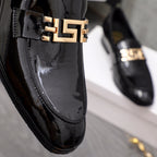 Versace black patent loafer close-up of gold logo buckle on vamp