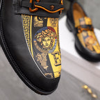 Versace loafer detail: black leather with gold baroque panel and orange-brown buckle
