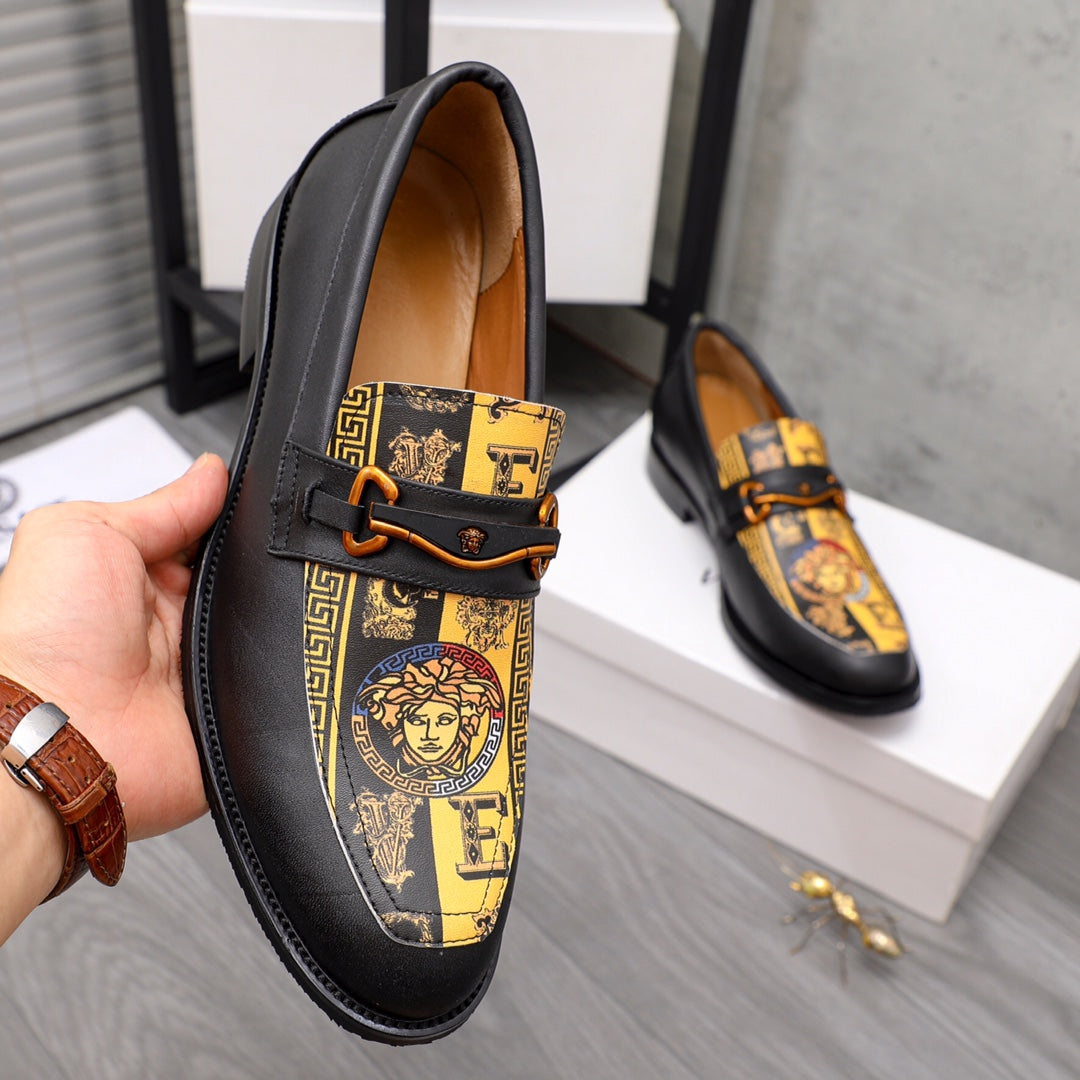 Versace loafer shoe with black leather, gold panel, and orange-brown strap buckle