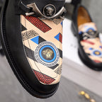 Versace loafer close-up: black leather with patterned fabric vamp and silver medallion