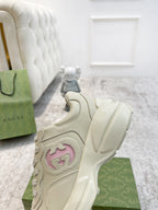 Cream Gucci sneaker side close-up, pink logo patch on chunky sole