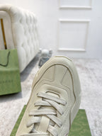 Cream Gucci sneaker front panel close-up, white laces and stitched upper