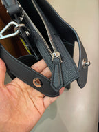 Fendi handbag close-up of strap hardware with silver grommets and zip pockets inside