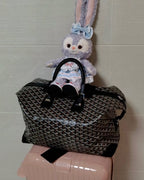 Tote bag with dark monogram pattern, top handles, and adjustable shoulder strap.