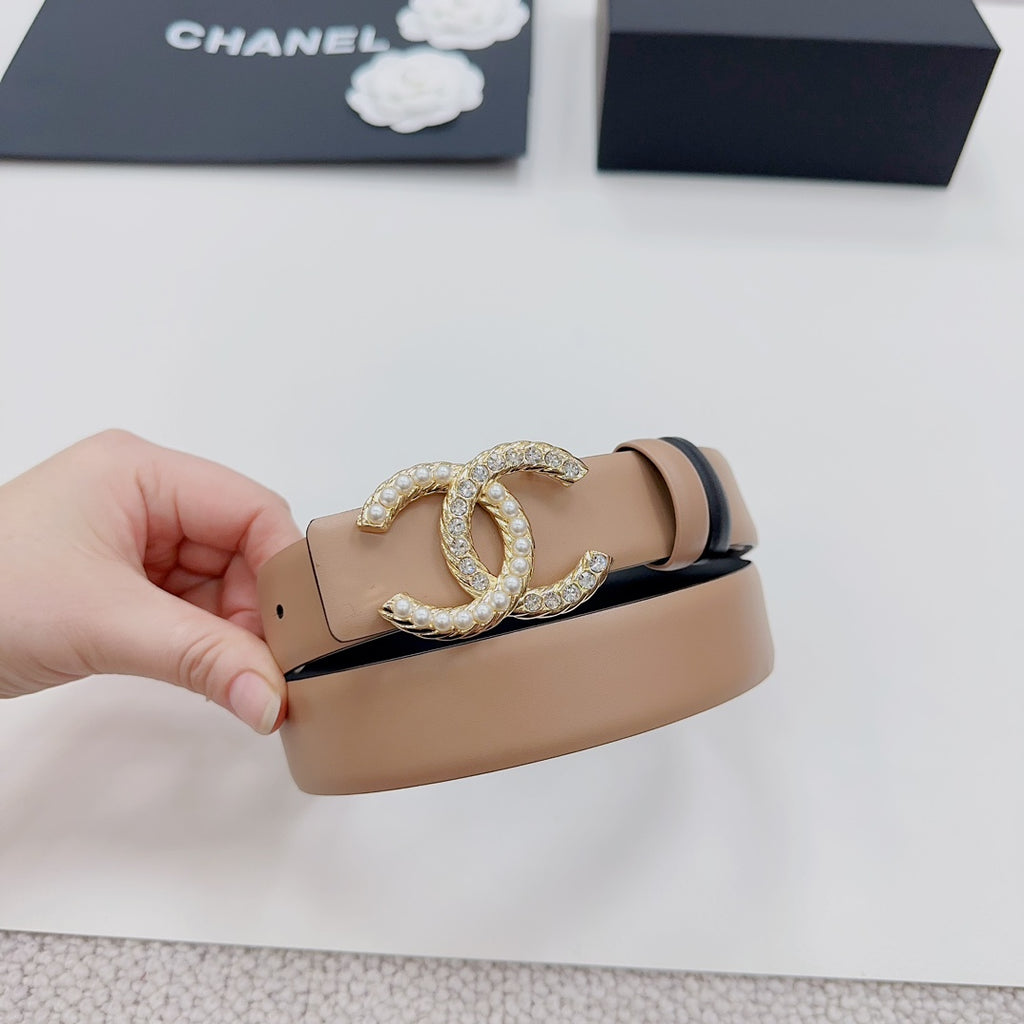 Tan leather belt with navy trim and gold-tone double-C crystal buckle close-up