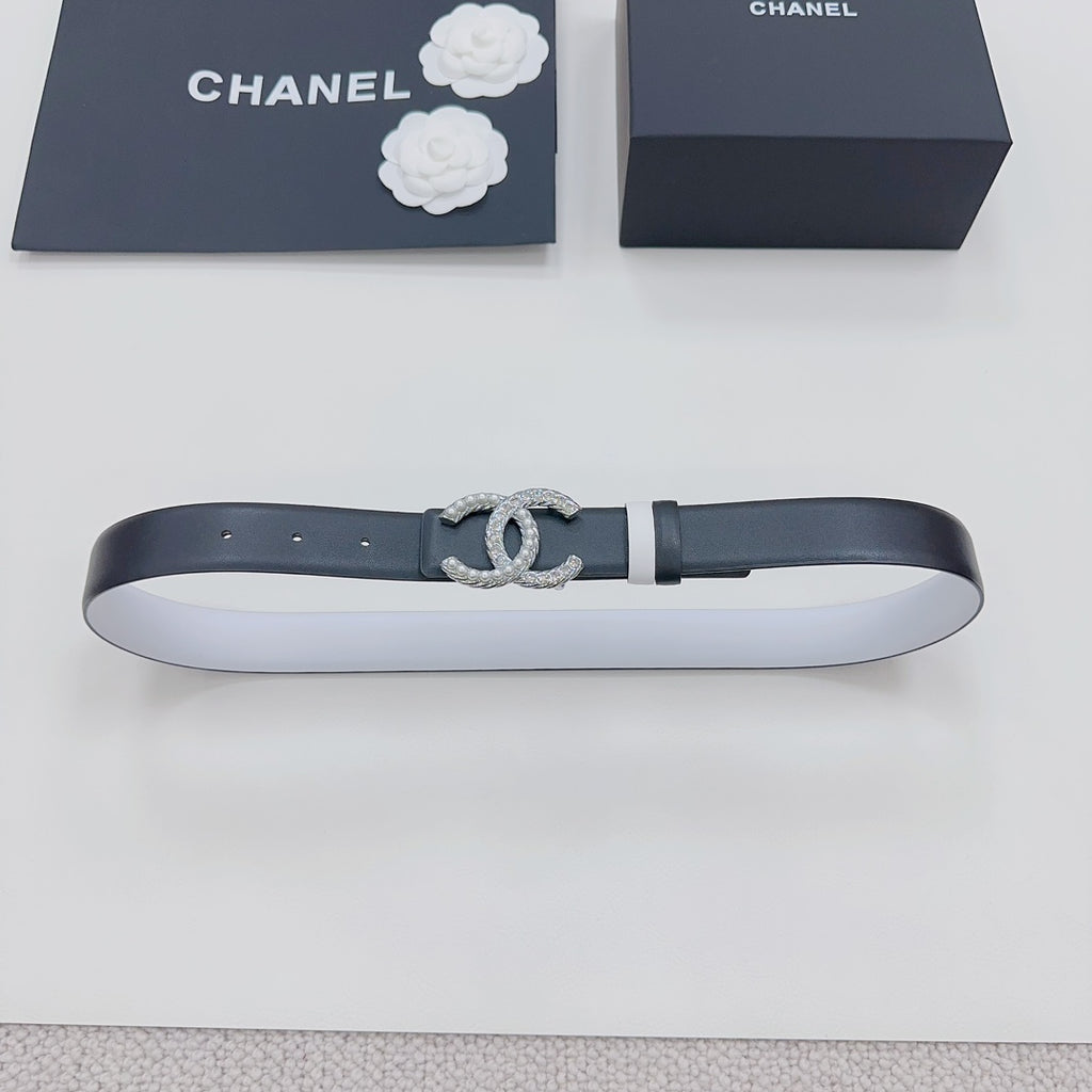 Dark leather belt laid flat with silver rhinestone CC buckle and metal keeper