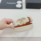 Chanel belt held in hand: beige strap with orange edge and gold-tone CC clasp.