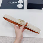 Chanel belt laid flat: beige textured strap, orange lining, gold CC buckle.