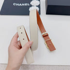 Chanel belt close-up: beige strap with orange leather end and gold-tone buckle.
