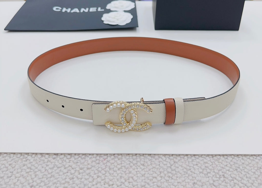 Chanel belt with circular profile: beige strap, orange edge, gold-tone CC buckle.