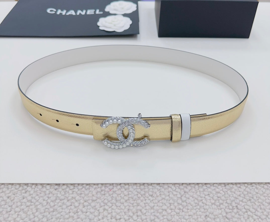Gold-tone belt with silver CC rhinestone buckle, laid flat on white