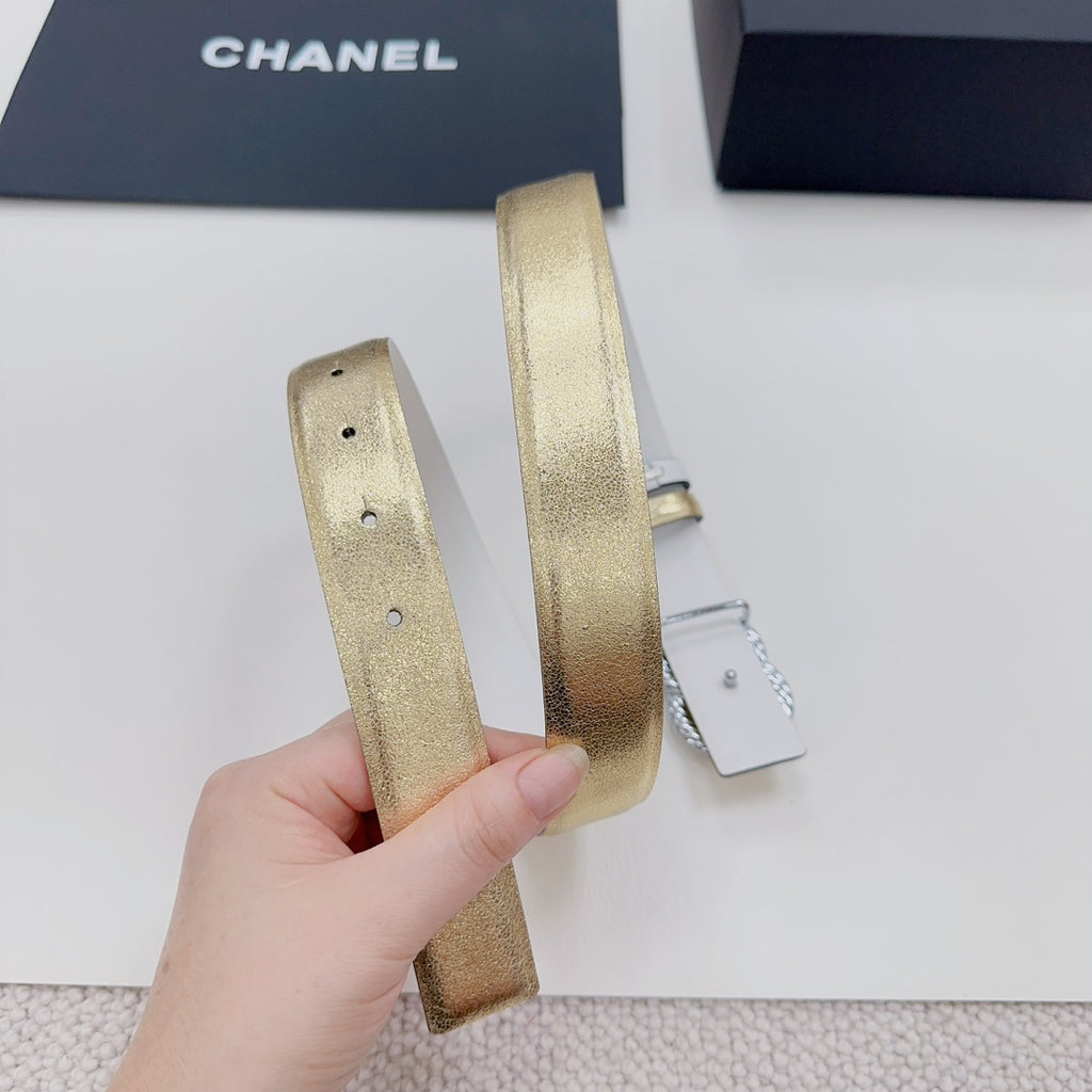 Gold-tone belt straps with stitch holes and buckle loop, held side view
