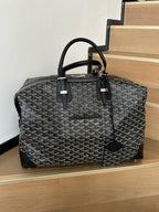 Tote bag with gray monogram fabric, top handles, and black leather trim details.
