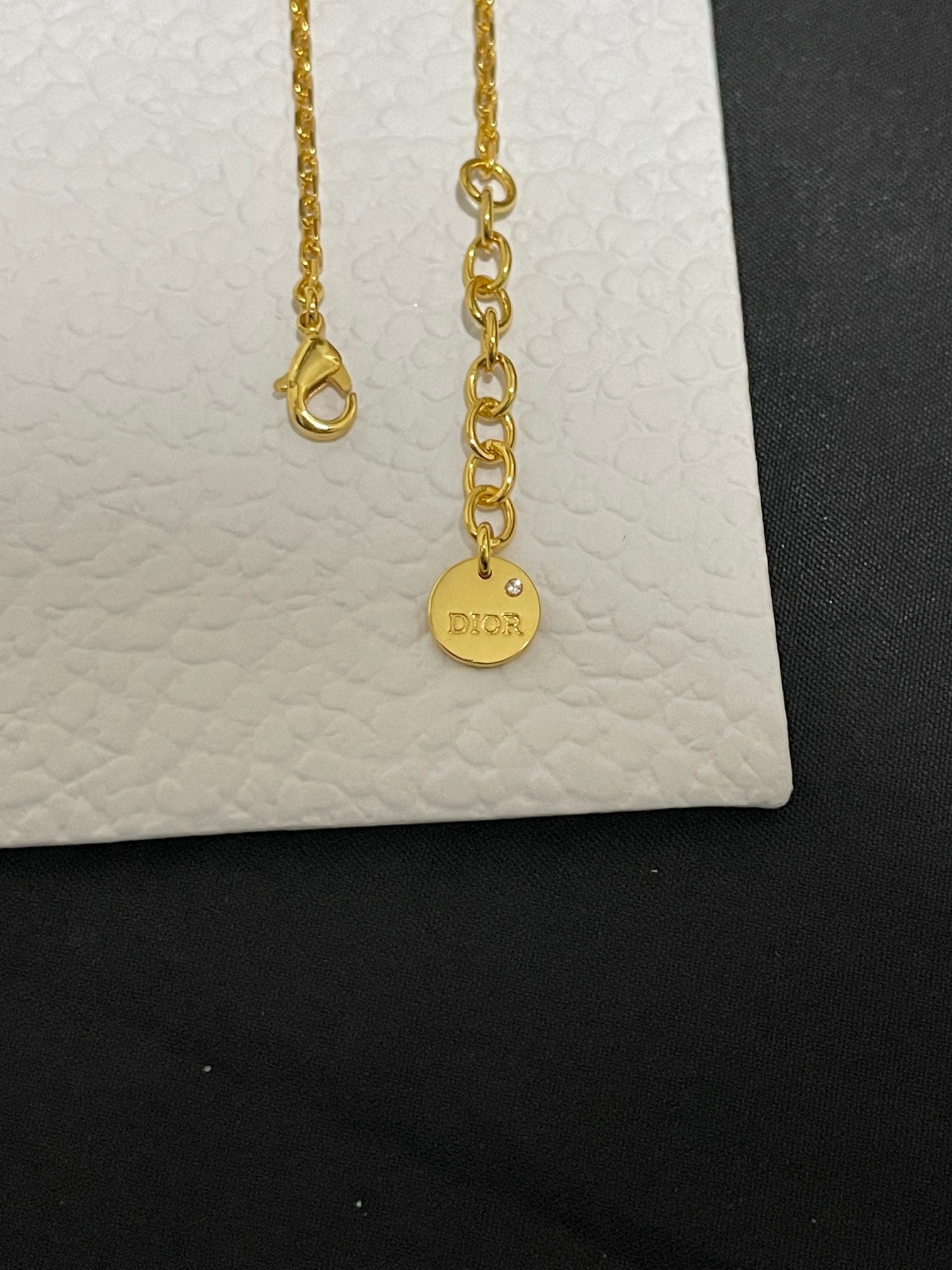 Gold-tone charm bracelets with round Dior logo charm and drop ends