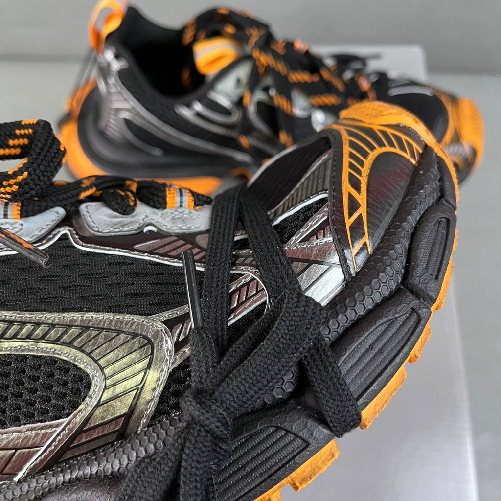 Balenciaga unisex chunky sneakers, close-up of black mesh and silver panel with orange trim