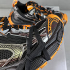 Balenciaga unisex chunky sneakers, close-up of black mesh and silver panel with orange trim