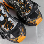 Balenciaga unisex chunky sneakers, side view with black mesh, silver panels, orange trim