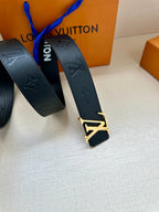 Louis Vuitton belt, dark blue leather with embossed monogram and gold-tone buckle detail.