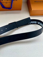 Dark gray leather belt with embossed monogram pattern, partial buckle view