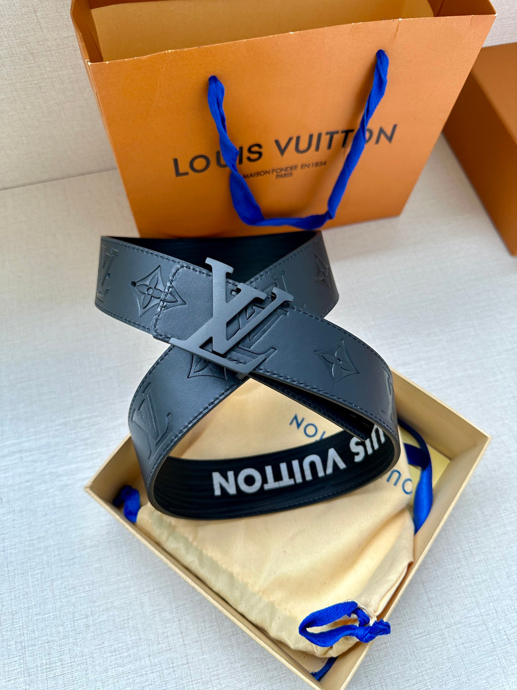 Dark gray leather belt with embossed monogram and silver-tone LV buckle detail