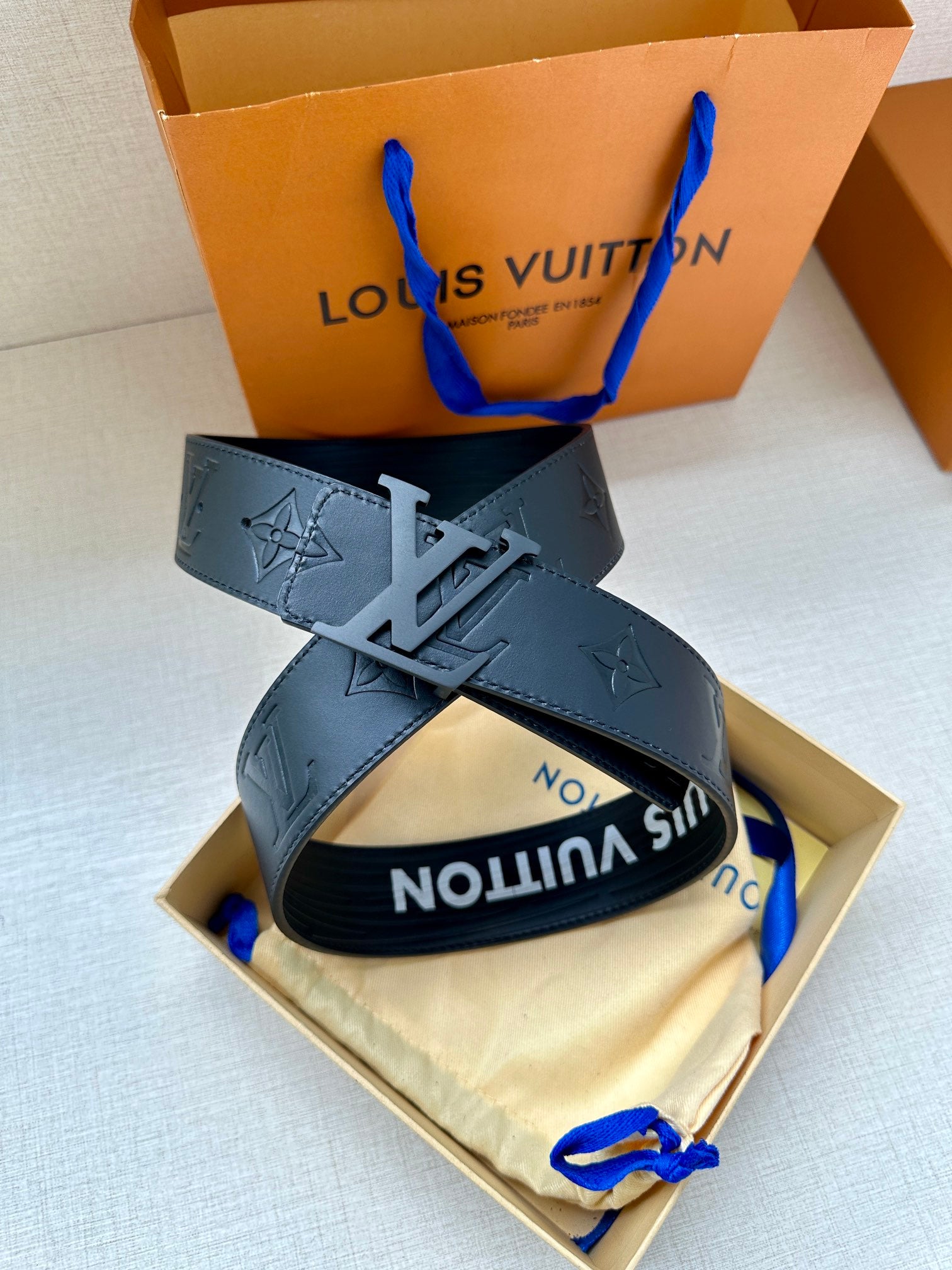 Dark gray leather belt with embossed monogram and silver-tone LV buckle detail