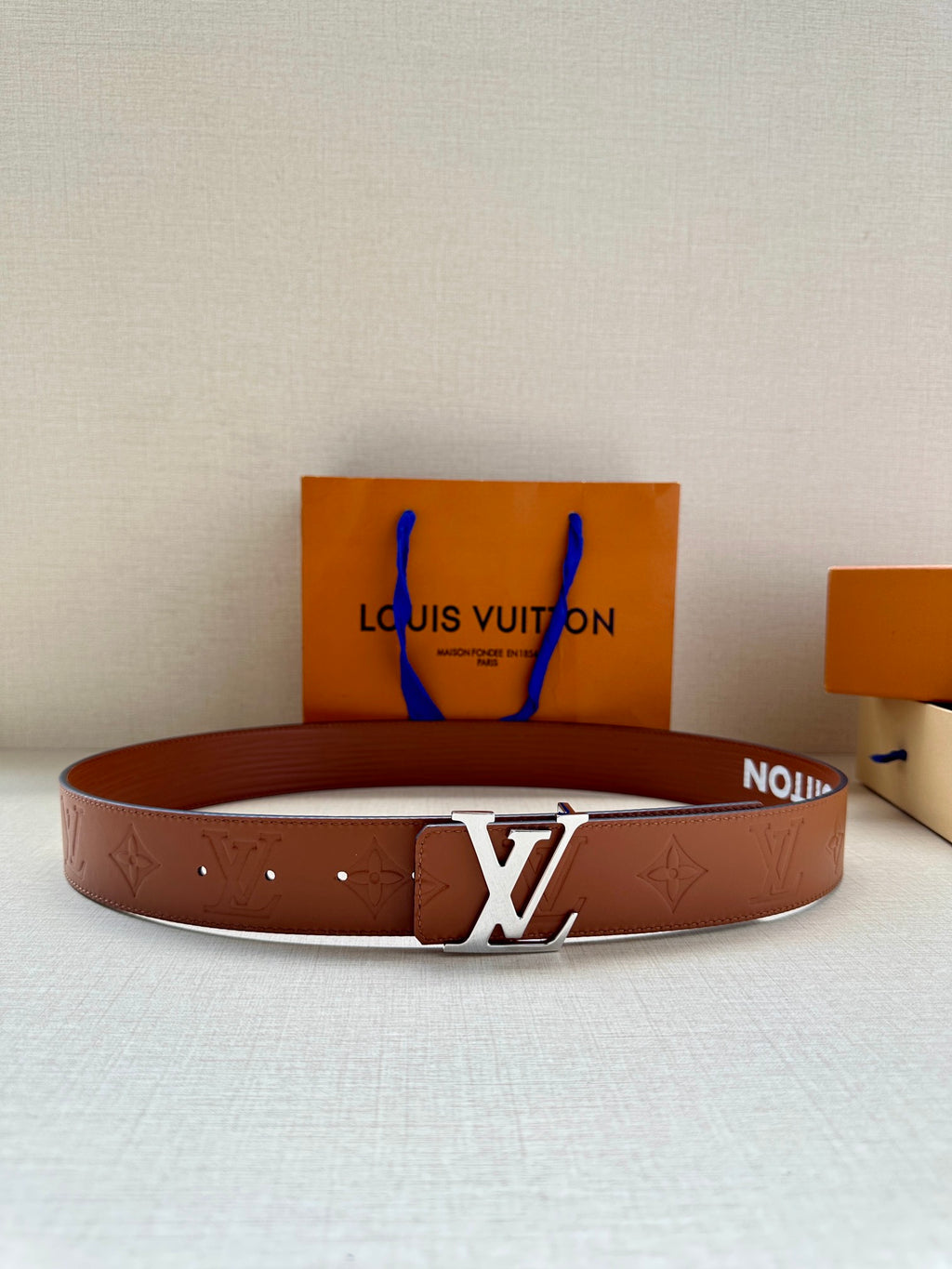Louis Vuitton leather belt in brown with embossed pattern and silver-tone LV buckle