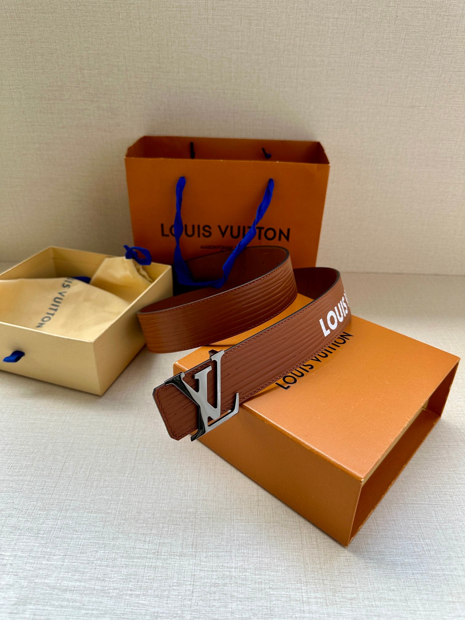 Louis Vuitton belt in brown with embossed texture and silver-tone LV buckle on box