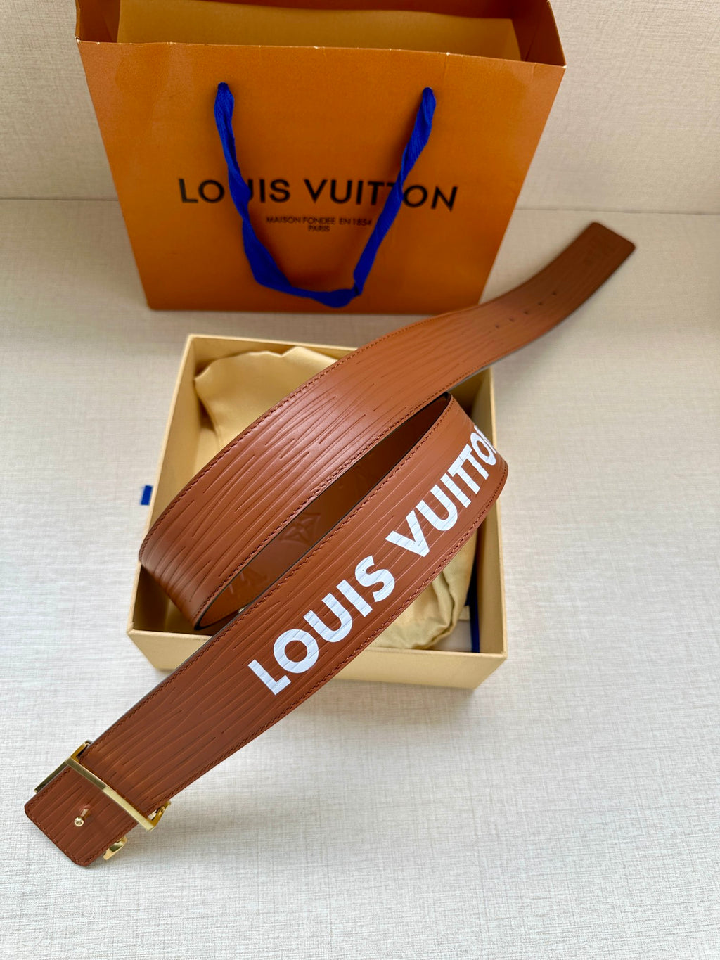 Louis Vuitton leather belt in brown with embossed texture and wide strap buckle