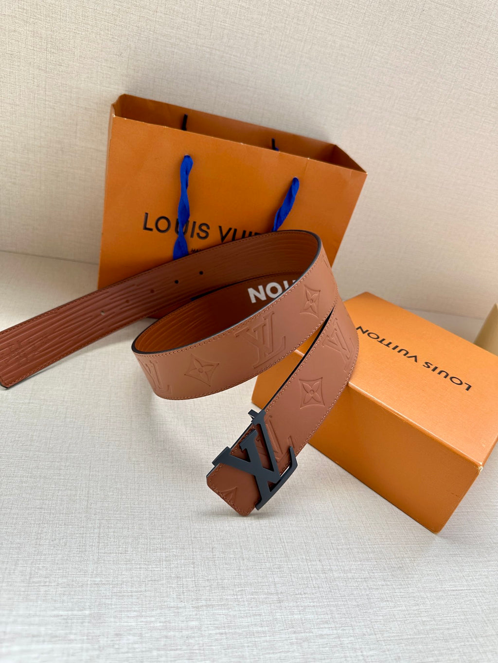 Monogram leather belt loop with dark LV buckle and embossed texture