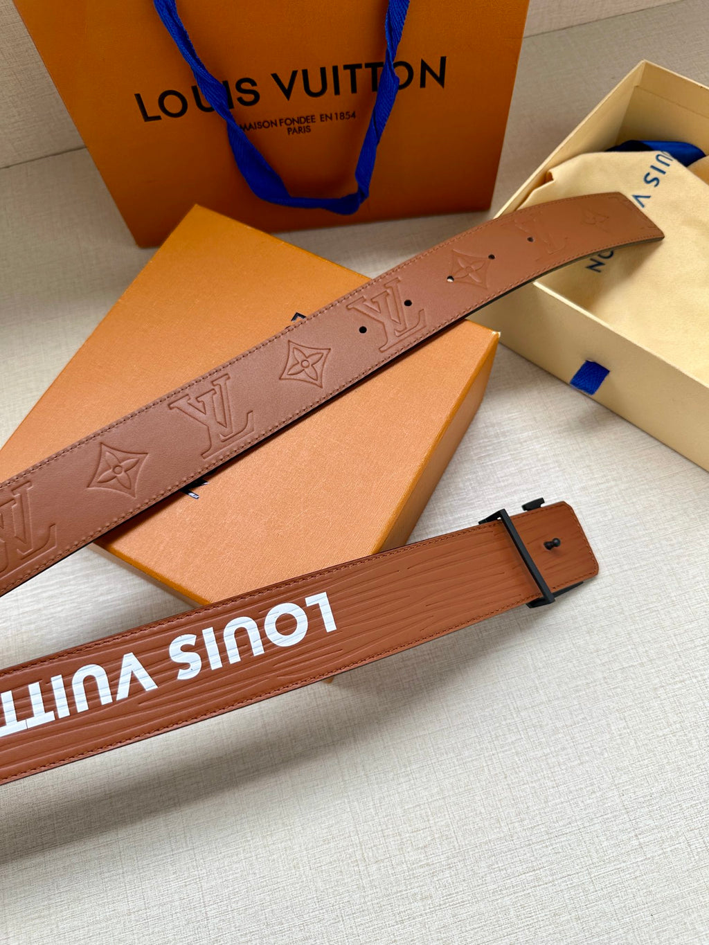 Monogram leather belt detail with embossed LV pattern and pin holes
