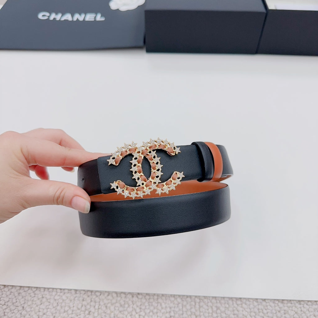 Chanel belt held up: tan strap with dark edge and ornate gold-tone CC star buckle