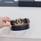 Chanel belt held up: tan strap with dark edge and ornate gold-tone CC star buckle