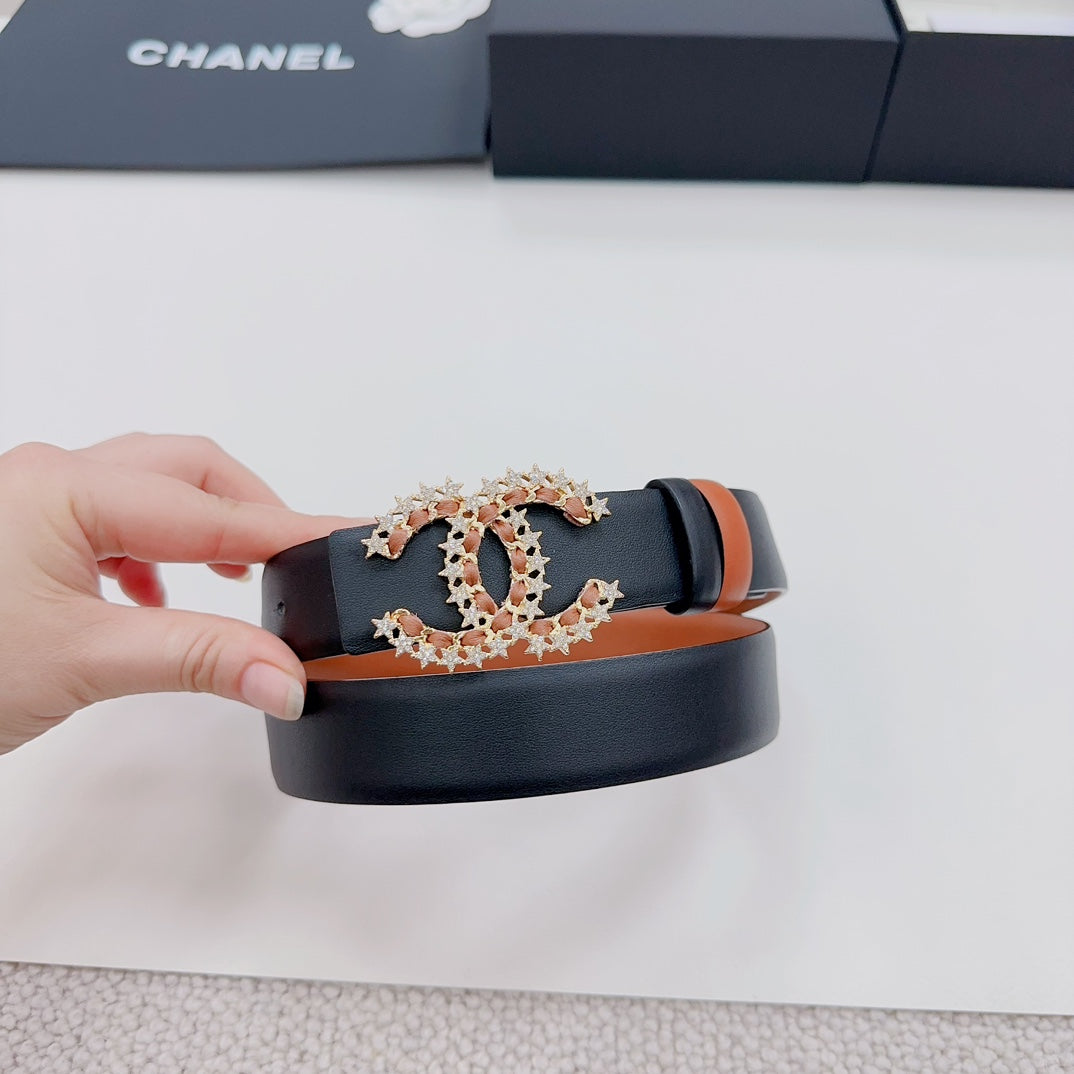 Chanel belt held up: tan strap with dark edge and ornate gold-tone CC star buckle