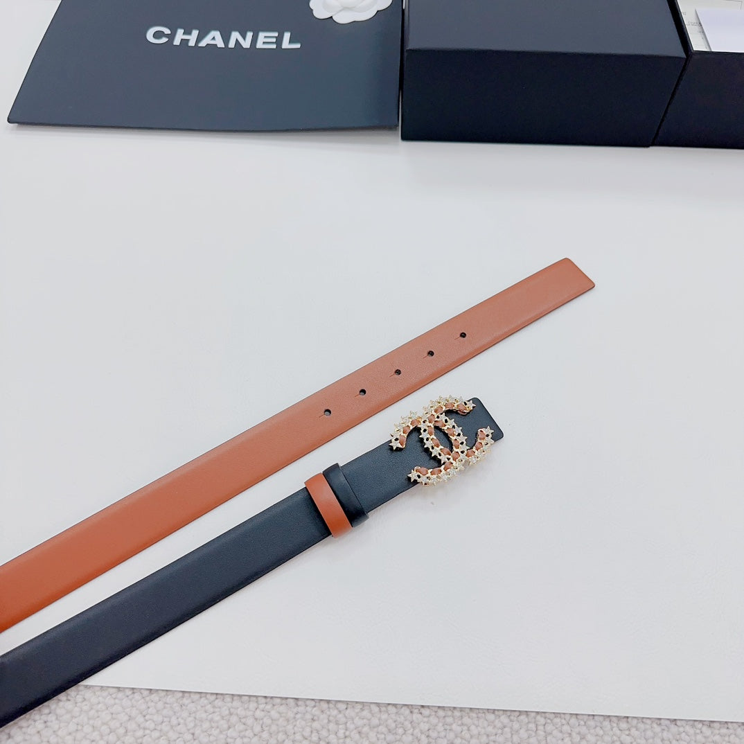 Chanel belt detail: tan strap with dark underside and ornate gold-tone CC star buckle
