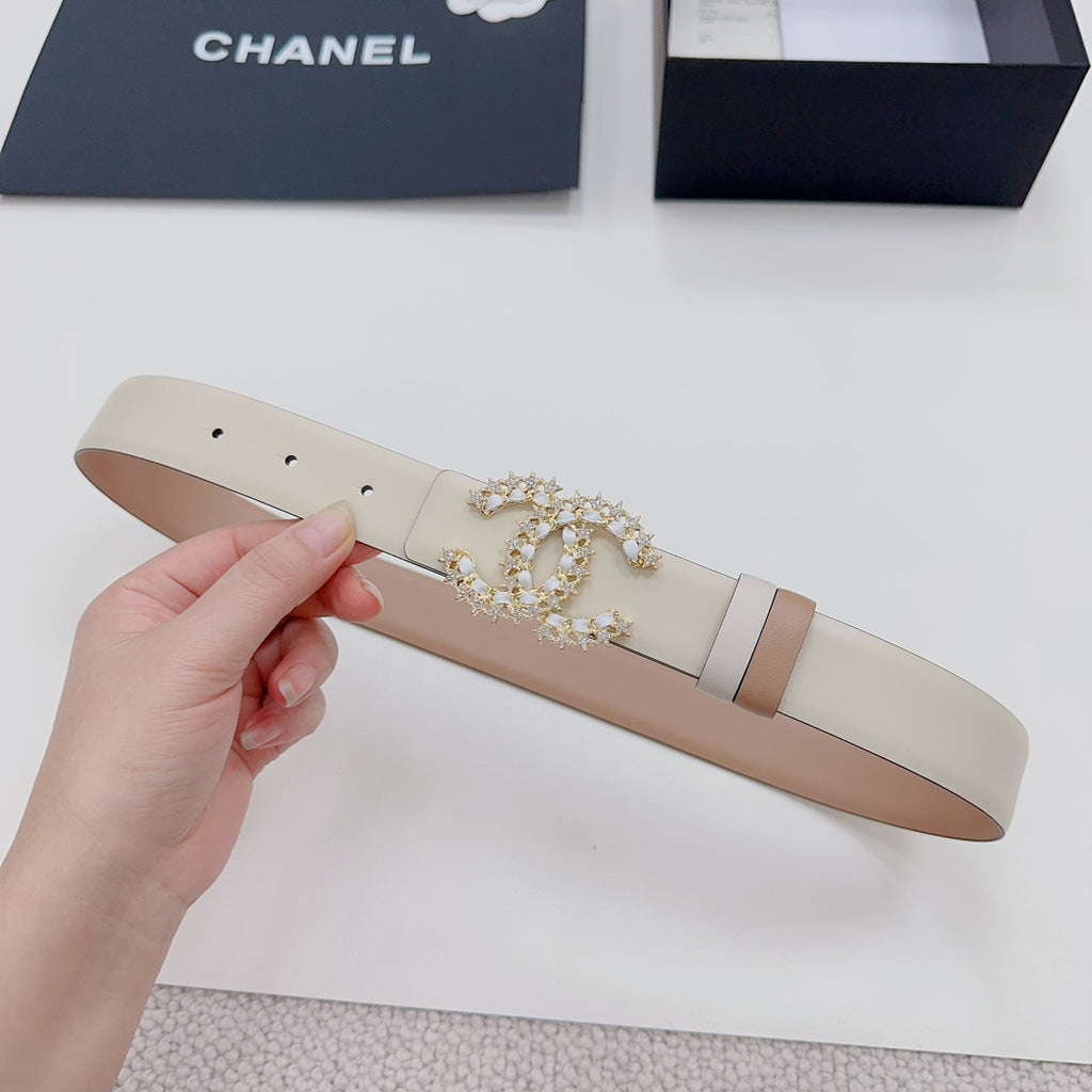 Beige leather belt with gold-tone embellished buckle and light leather keeper strap.